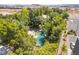 A private backyard oasis featuring a uniquely shaped pool and lush, mature landscaping for a serene escape at 10445 Schirlls St, Las Vegas, NV 89141