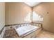 Soaking tub with marble accents and a unique glass block window at 10445 Schirlls St, Las Vegas, NV 89141