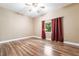 Bedroom featuring hardwood floors, a window with red curtains, a ceiling fan, and neutral walls at 10445 Schirlls St, Las Vegas, NV 89141