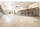 This is a large garage with shelving and a roll up door to the outside at 10445 Schirlls St, Las Vegas, NV 89141