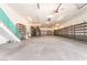 A spacious garage area with shelving, stairs, and a concrete floor at 10445 Schirlls St, Las Vegas, NV 89141