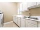 Functional laundry room with sink, ample counter space, and crisp white cabinets at 10445 Schirlls St, Las Vegas, NV 89141