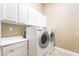 Laundry room with a side-by-side washer and dryer, and overhead cabinets at 10445 Schirlls St, Las Vegas, NV 89141