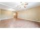 View of living room with tan walls, tile floor, and two ceiling fans at 10445 Schirlls St, Las Vegas, NV 89141