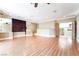 Spacious living room featuring hardwood floors, mirrored wall accents, and balcony access at 10445 Schirlls St, Las Vegas, NV 89141