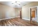 Spacious main bedroom with hardwood floors, a ceiling fan, and access to an ensuite bathroom at 10445 Schirlls St, Las Vegas, NV 89141