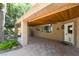Charming covered patio with wood ceilings, tile flooring, and mature landscaping at 10445 Schirlls St, Las Vegas, NV 89141