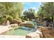 Spectacular rock pool with spa, perfect for relaxation amidst mature trees and lush landscaping at 10445 Schirlls St, Las Vegas, NV 89141