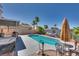 Lush backyard with a sparkling swimming pool, shady patio, and a comfortable hammock, perfect for relaxation at 1048 Menands Ave, Las Vegas, NV 89123