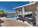 A private backyard with a refreshing pool, covered patio, mature palm trees, and ample space for relaxation at 1048 Menands Ave, Las Vegas, NV 89123