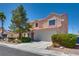 Inviting two-story home with a large front yard, a two-car garage, and mature landscaping at 1048 Menands Ave, Las Vegas, NV 89123
