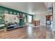 Bright living room featuring hardwood floors and a green accent wall, open to other areas of the home at 1048 Menands Ave, Las Vegas, NV 89123
