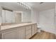 Bathroom featuring a granite countertop double vanity, a large mirror, and shower-tub combo at 10550 W Alexander Rd # 2220, Las Vegas, NV 89129