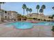 Inviting community pool area with lounging chairs, palm trees, and beautiful building views surrounded by lush foliage at 10550 W Alexander Rd # 2220, Las Vegas, NV 89129