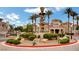 Community entrance with palm trees, desert landscaping, and a monument water feature at 10550 W Alexander Rd # 2220, Las Vegas, NV 89129