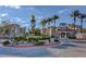Exterior view of community center, with a circular drive, lush landscaping, and palm trees at 10550 W Alexander Rd # 2220, Las Vegas, NV 89129