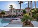 Exterior shot of community pool, and hot tub with lush landscaping and lounge chairs under palm trees at 10550 W Alexander Rd # 2220, Las Vegas, NV 89129