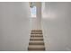Bright stairway with a landing halfway up, featuring neutral carpeting and a small window at 10550 W Alexander Rd # 2220, Las Vegas, NV 89129