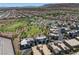 Aerial view showcasing a community featuring an artificial turf field, walking paths, and numerous houses at 11239 Cactus Tower Ave # 102, Las Vegas, NV 89135
