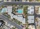 Aerial view of a community featuring a large, light blue pool, palm trees, seating, and multiple buildings at 11239 Cactus Tower Ave # 102, Las Vegas, NV 89135