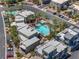 Aerial view of a light blue community pool, palm trees, modern buildings, and lush landscaping at 11239 Cactus Tower Ave # 102, Las Vegas, NV 89135