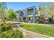 Modern townhome showcasing a manicured lawn, stucco facade, recessed balconies, and mature landscaping at 11239 Cactus Tower Ave # 102, Las Vegas, NV 89135