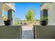 Front entrance view through gated stucco wall showcasing stone walkway, landscaping, and mountain views at 11239 Cactus Tower Ave # 102, Las Vegas, NV 89135