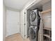 Modern laundry room equipped with stacked washer and dryer units, shelves, and a wood-look floor at 11239 Cactus Tower Ave # 102, Las Vegas, NV 89135