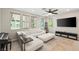 Bright living room with white leather couches, a ceiling fan, and natural light showcasing the modern interior design at 11239 Cactus Tower Ave # 102, Las Vegas, NV 89135
