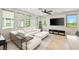 Bright living room with white leather couches, a ceiling fan, and natural light showcasing the modern interior design at 11239 Cactus Tower Ave # 102, Las Vegas, NV 89135