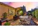 Backyard patio with outdoor dining set, umbrella, and an outdoor kitchen framed by beautiful landscaping at 12276 Caminita Pl, Las Vegas, NV 89138