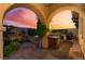 An outdoor kitchen with a barbecue grill and outdoor sink, framed by the beautiful colors of dusk at 12276 Caminita Pl, Las Vegas, NV 89138