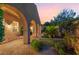 Backyard space with pavers, arched architectural details, manicured garden beds, and patio furniture at 12276 Caminita Pl, Las Vegas, NV 89138