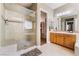 Bathroom featuring tiled walk-in shower, double sinks, and natural light, creating a clean and modern space at 12276 Caminita Pl, Las Vegas, NV 89138
