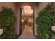Inviting arched entrance with a lush, landscaped walkway leading to a charming home at 12276 Caminita Pl, Las Vegas, NV 89138