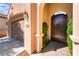 Front entrance showcases an arched gate, desert landscaping and a direct-access garage at 12276 Caminita Pl, Las Vegas, NV 89138