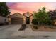 Charming single-story home with desert landscaping and warm exterior lighting during sunset at 12276 Caminita Pl, Las Vegas, NV 89138