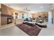 Spacious living room with a fireplace, comfortable seating, and open layout to the kitchen at 12276 Caminita Pl, Las Vegas, NV 89138