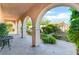 Inviting covered patio showcasing elegant arches, landscaped planters, and stylish brick pavers at 12276 Caminita Pl, Las Vegas, NV 89138