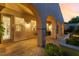 Covered patio with arched columns and a tiled floor, offering a comfortable outdoor living space at twilight at 12276 Caminita Pl, Las Vegas, NV 89138