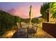 Charming patio with a dining table, garden umbrella, and privacy hedges, perfect for outdoor entertaining at 12276 Caminita Pl, Las Vegas, NV 89138