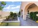 Covered patio with arched supports and lush landscaping, creating a serene and inviting outdoor space at 12276 Caminita Pl, Las Vegas, NV 89138