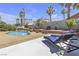 Inviting backyard with a swimming pool, lounge chairs, and lush greenery at 1877 Glory Lily Ct, Las Vegas, NV 89123