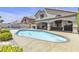 Spacious backyard with a swimming pool, covered patio, and lush landscaping at 1877 Glory Lily Ct, Las Vegas, NV 89123