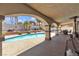 A beautifully landscaped backyard with a pool, covered patio, and inviting outdoor spaces for entertaining at 1877 Glory Lily Ct, Las Vegas, NV 89123