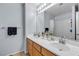 Bathroom with double sinks, wooden cabinets, and modern fixtures at 1877 Glory Lily Ct, Las Vegas, NV 89123