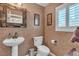 Stylish powder room with pedestal sink, decorative mirror, and unique textured walls at 1877 Glory Lily Ct, Las Vegas, NV 89123