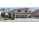 Charming two-story home featuring a neutral color palette, arched windows, and a well-maintained front yard at 1877 Glory Lily Ct, Las Vegas, NV 89123