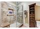 Bathroom featuring a glass shower, tiled walls, a built-in niche, and wood storage shelves at 2035 E Warm Springs Rd # 1019, Las Vegas, NV 89119