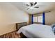Cozy bedroom featuring a ceiling fan, wood-look flooring, and a large window with blue curtains at 2035 E Warm Springs Rd # 1019, Las Vegas, NV 89119